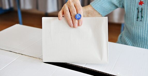 Frau wirft Stimmzettel in Wahlurne